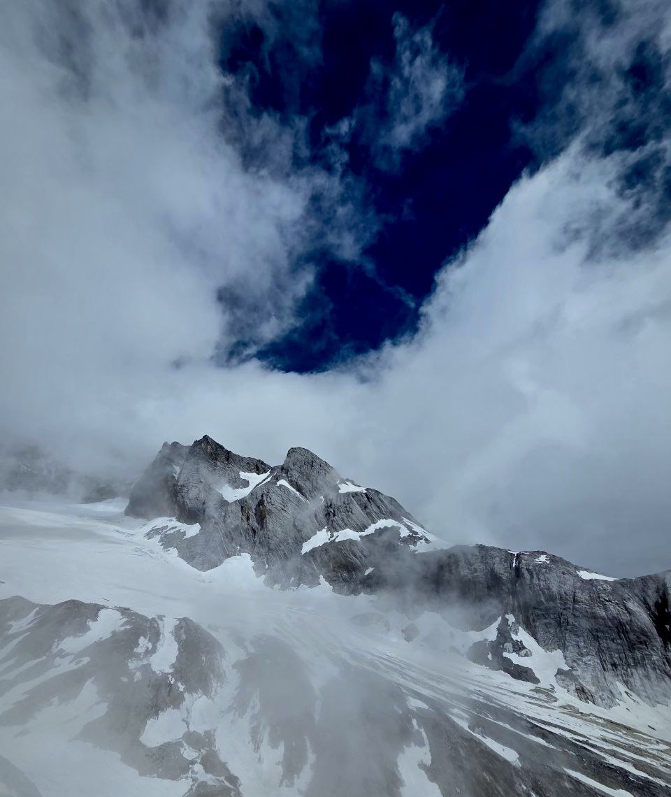 A snow peak in cloud, graded to a cold, dark tone.